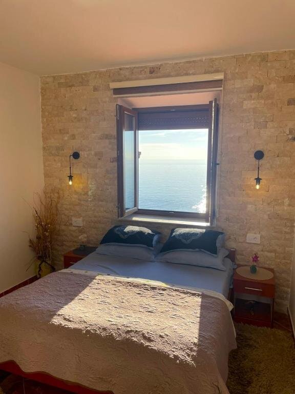 Bedroom with stone walls and sea view window